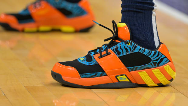 View of blue, black, and orange Adidas shoes.